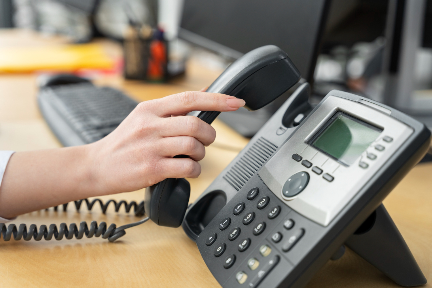 VoIP phone system with a hand on the phone